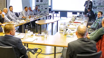 Experts from the automotive industry came together in the GKN Sinter Metals Innovation Center for the first AM Consulting Day. Men sitting around a u shaped table in a conference room