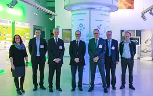 British Ambassador Visits Gkn Sinter Metals In Bonn. Image of people in suits standing together in an events space