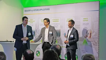 Image of 3 men giving a presentation on a stage